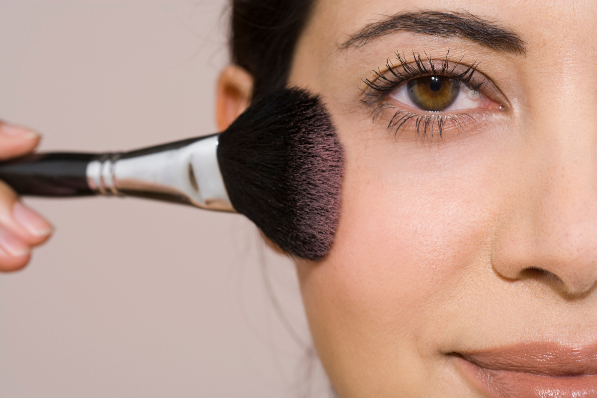 Model touching up blush.