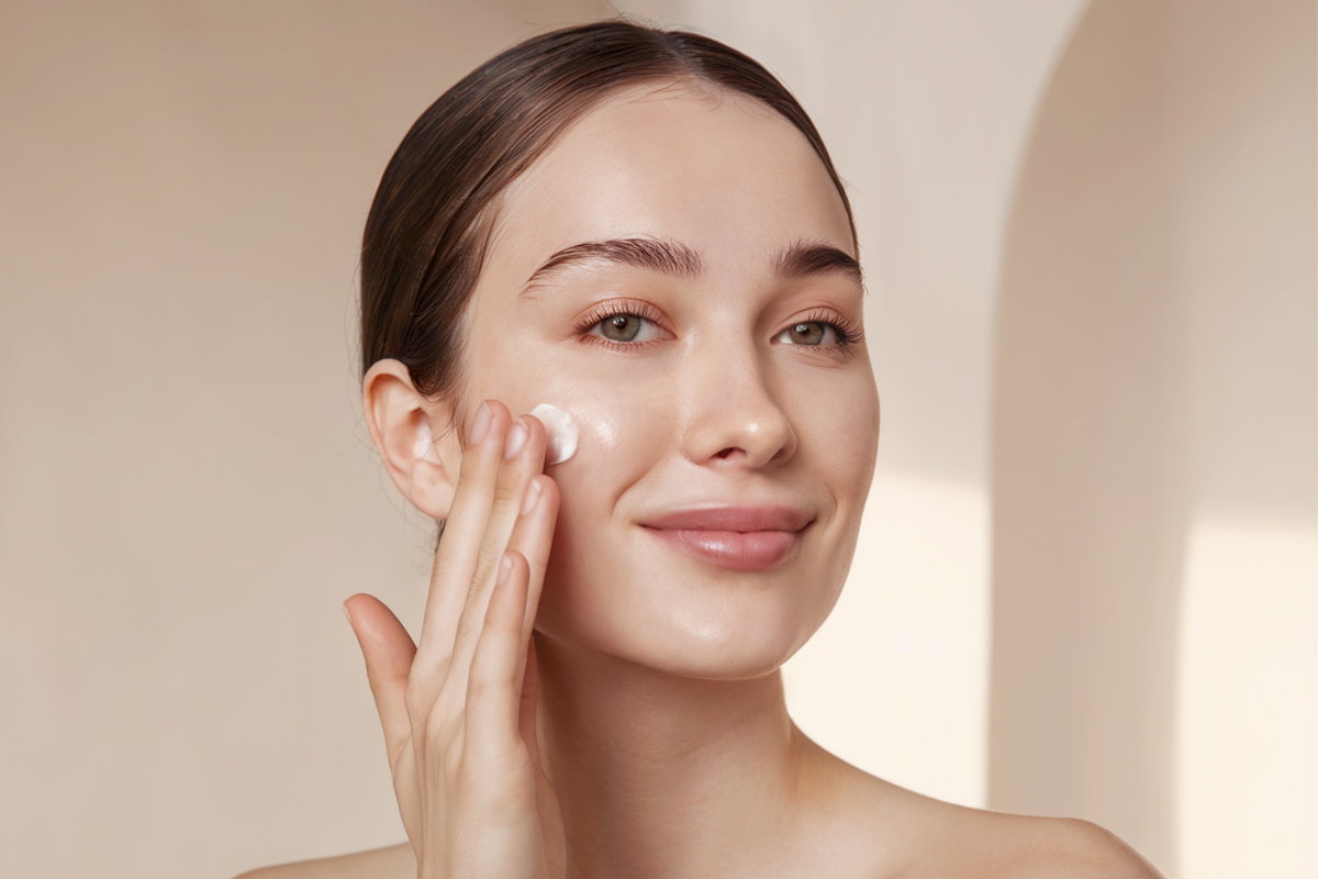 a woman moisturizing her face skin 